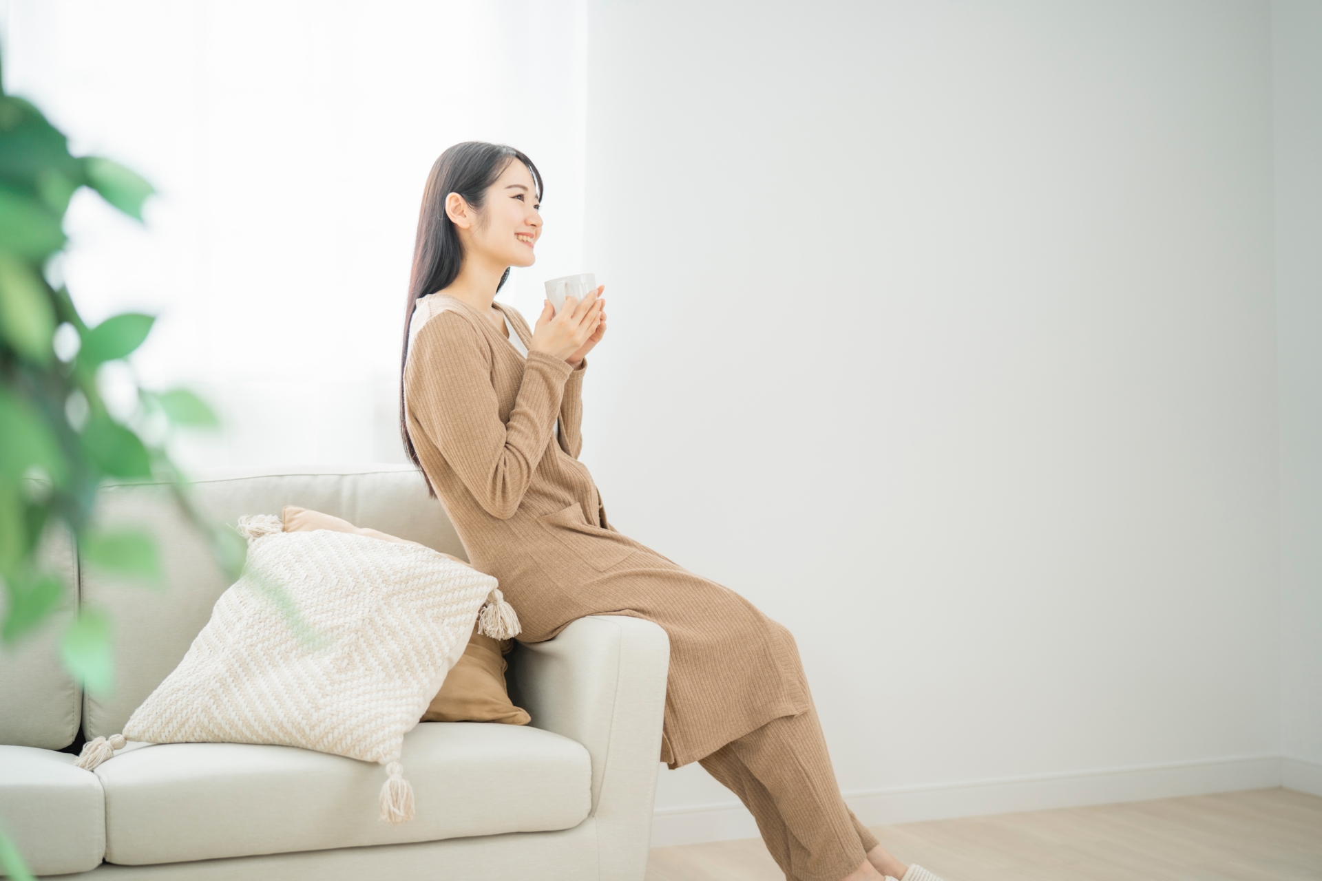 A woman holding a drink in a bright contemporary interior.