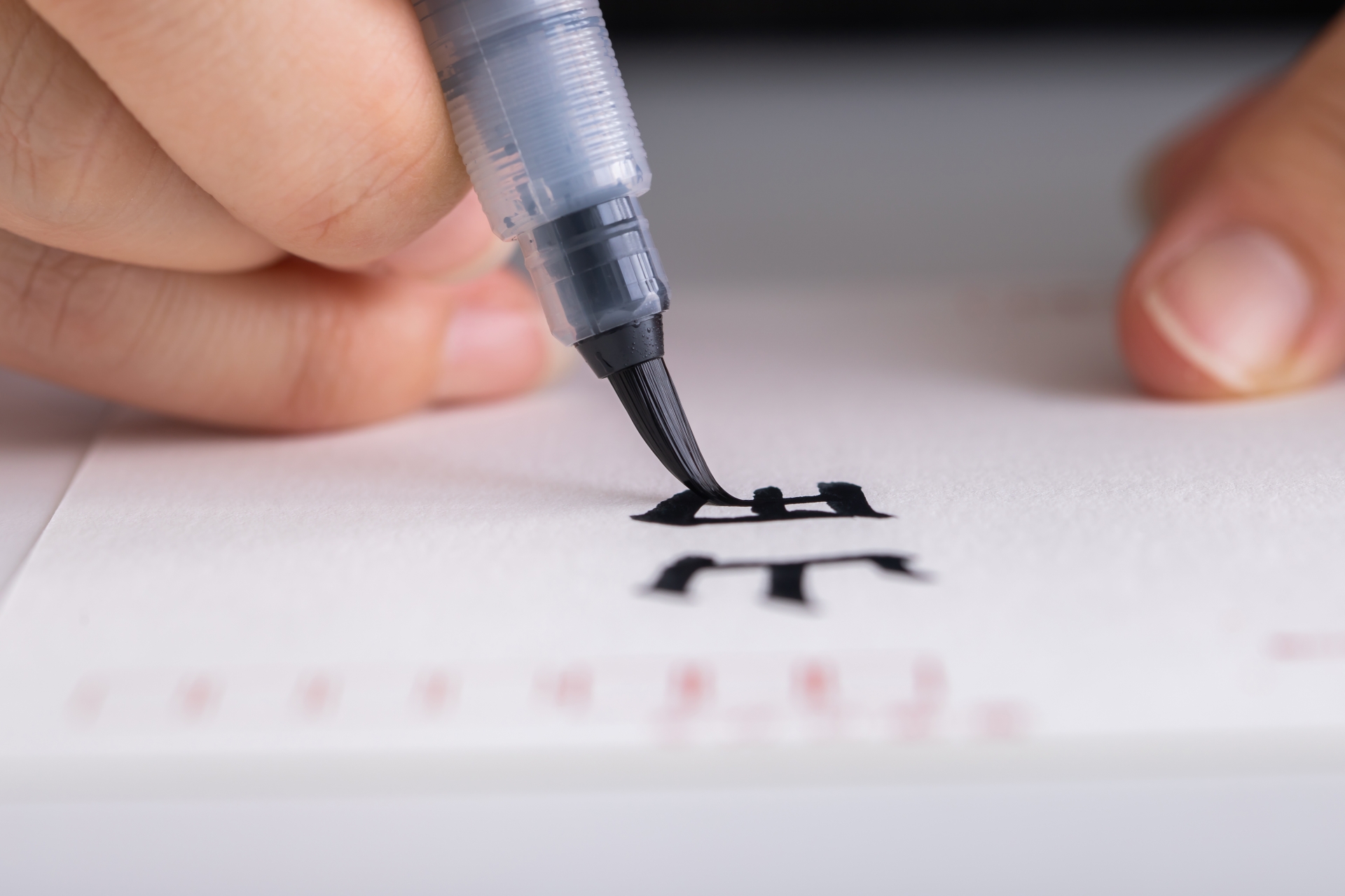 Brush pen tip writing a Japanese character.