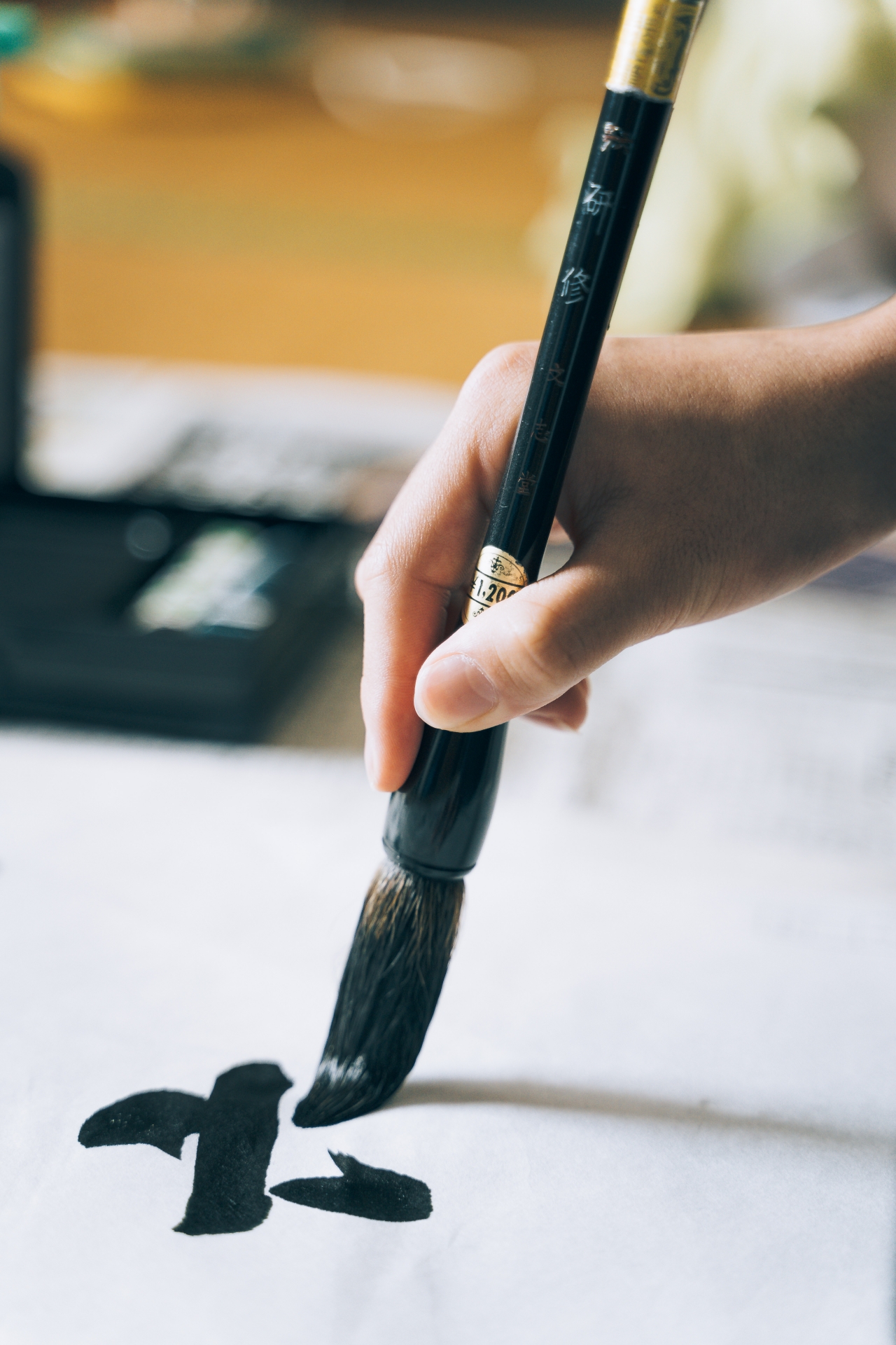 Hand writing Japanese calligraphy with a traditional brush.