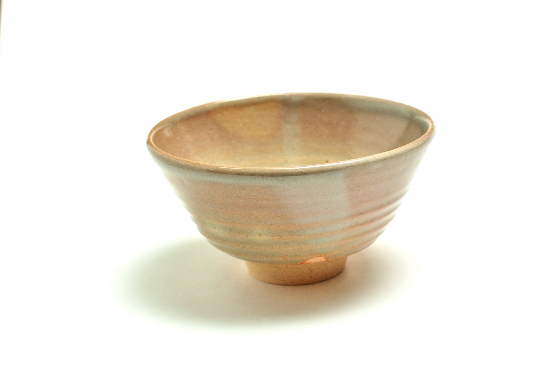 A Hagi pottery bowl with a pale, softly varied glaze and a raised foot.