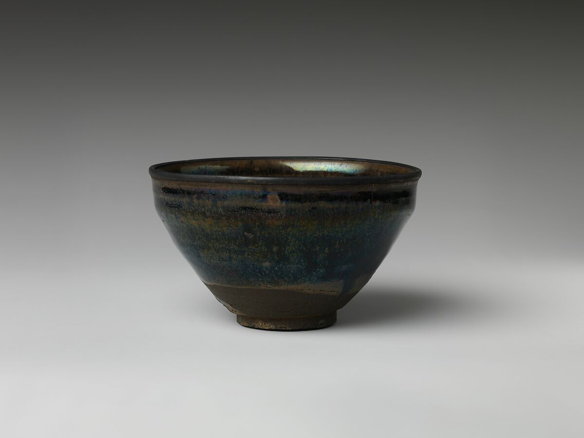 A Seto teabowl with a dark iron-oxide glaze and fine streaked surface.